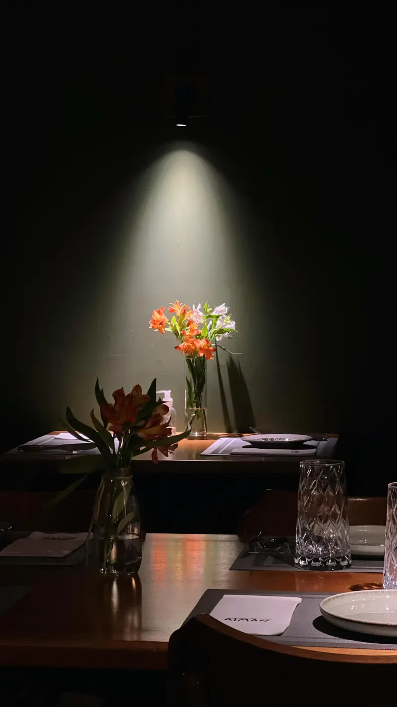 Mesa posta com flores sob a luz, no salão do Atman
