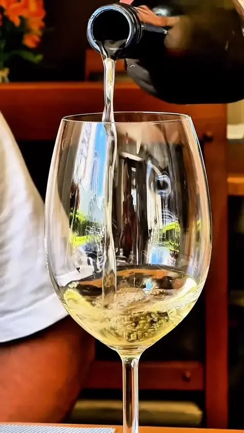Vinho branco sendo servido na taça